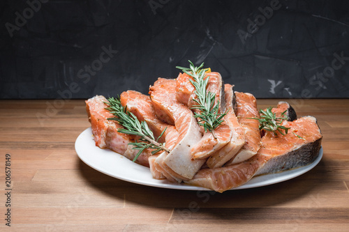 fresh raw red fish fillet on white plate and rosemary