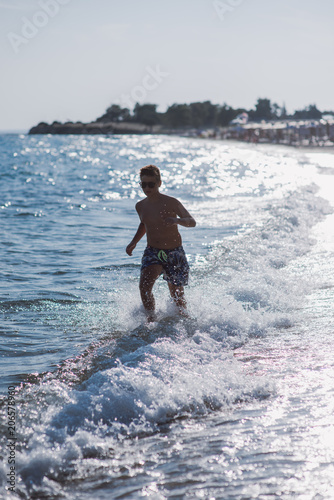Boy running in water on the beach