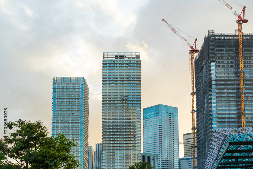 Tower mansion and building under construction against evening sky