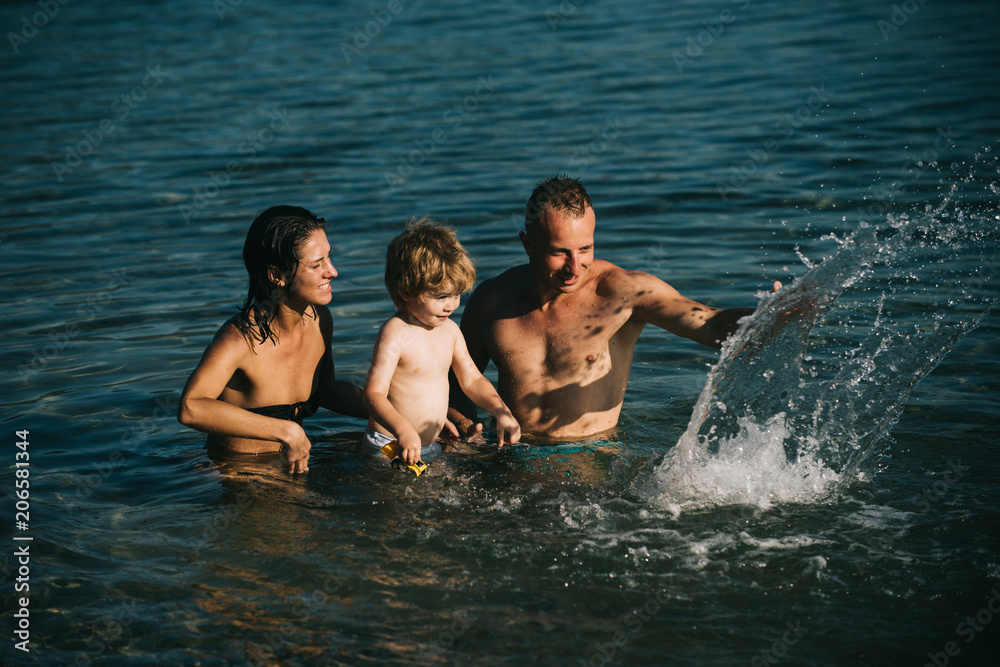 Happy family at a sea having fun and splashing water in summer. Happy family at a sea having fun and splashing water in summer.