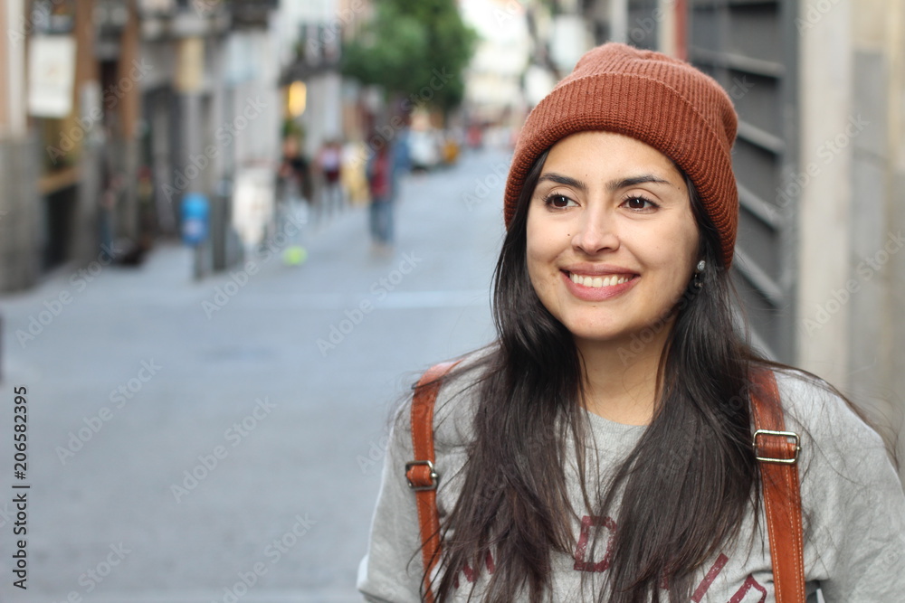 Cute Latin woman smiling on the street