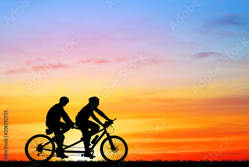 silhouette vintage bike and love couple on sunrise background