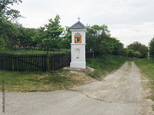 Pohor, Odry, Czech Republic - Authentic czech village and countryside - small cristian and catholic chapel, road and garden with green grass and fruit trees.  photo