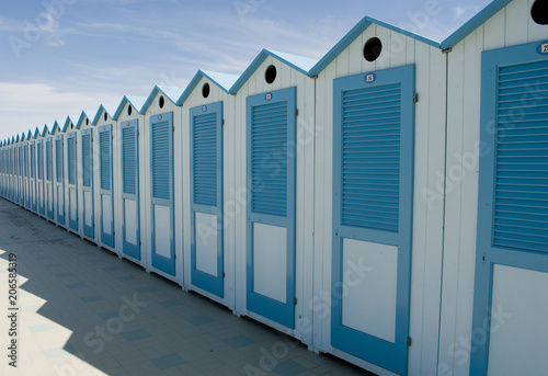 wooden beach cabins by the sea  changing rooms  blue and white  used to change and put on bathing suit  vacation  summer  sun  ligurian riviera  Albenga beach  Italy