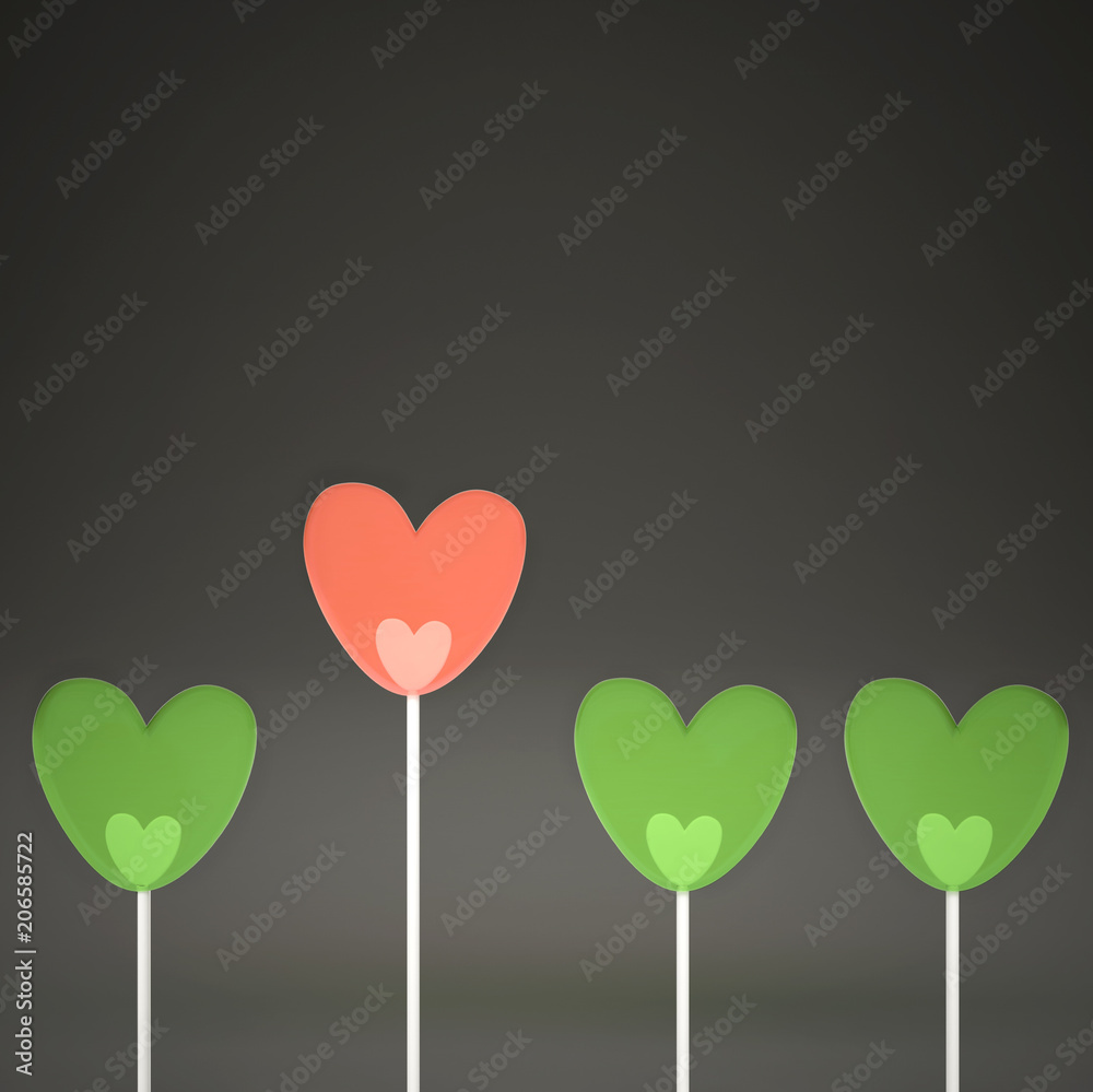 Minimal love and care concept idea, green and pink heart shape candies on gray pastel background with copy space