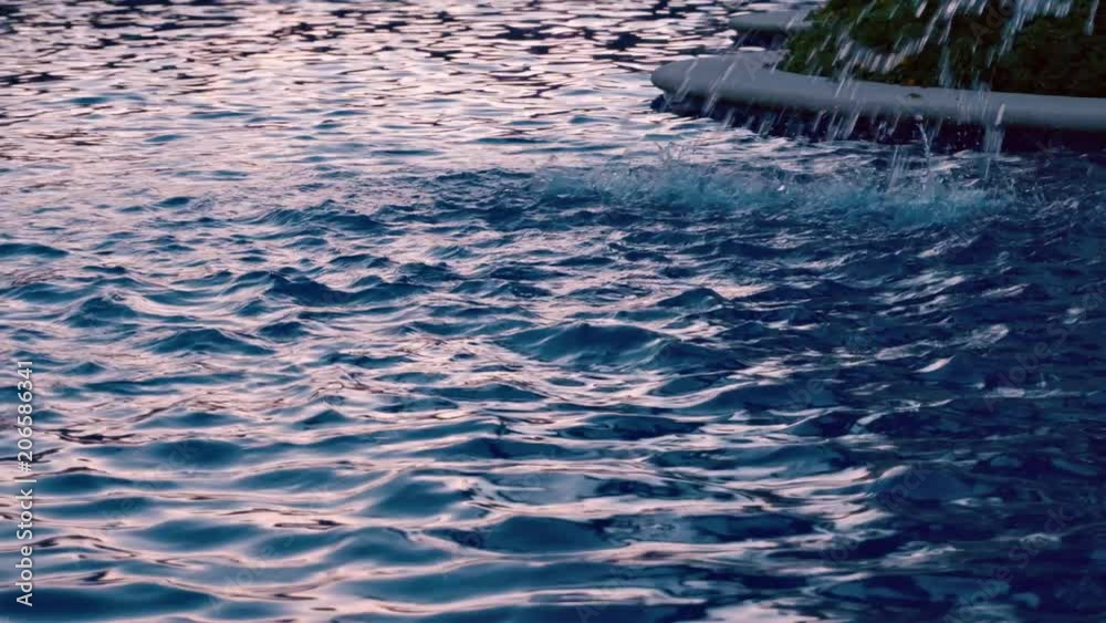 View at swimming pool of luxury resort hotel of tropical coast at sunset. Fountain jet of blue water. Riviera Maya Mexico. View at swimming pool of luxury resort hotel of tropical coast at sunset. Fountain jet of blue water. Riviera Maya Mexico.