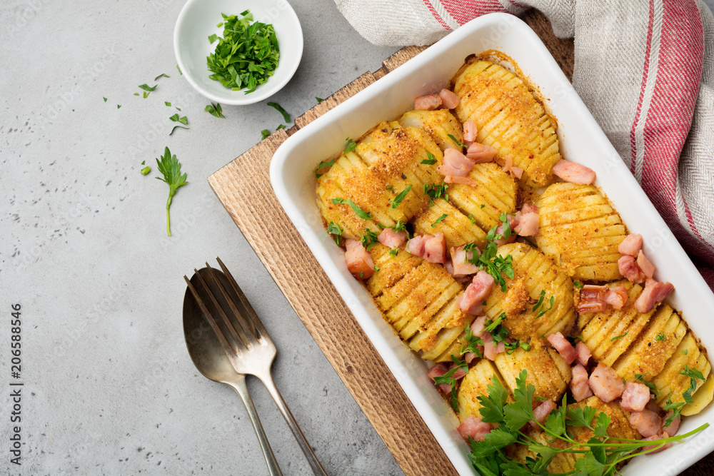 Baked potatoes with ham, herbs and breadcrumbs on gray light background. Scandinavian cuisine. Top view. Baked potatoes with ham, herbs and breadcrumbs on gray light background. Scandinavian cuisine. Top view.