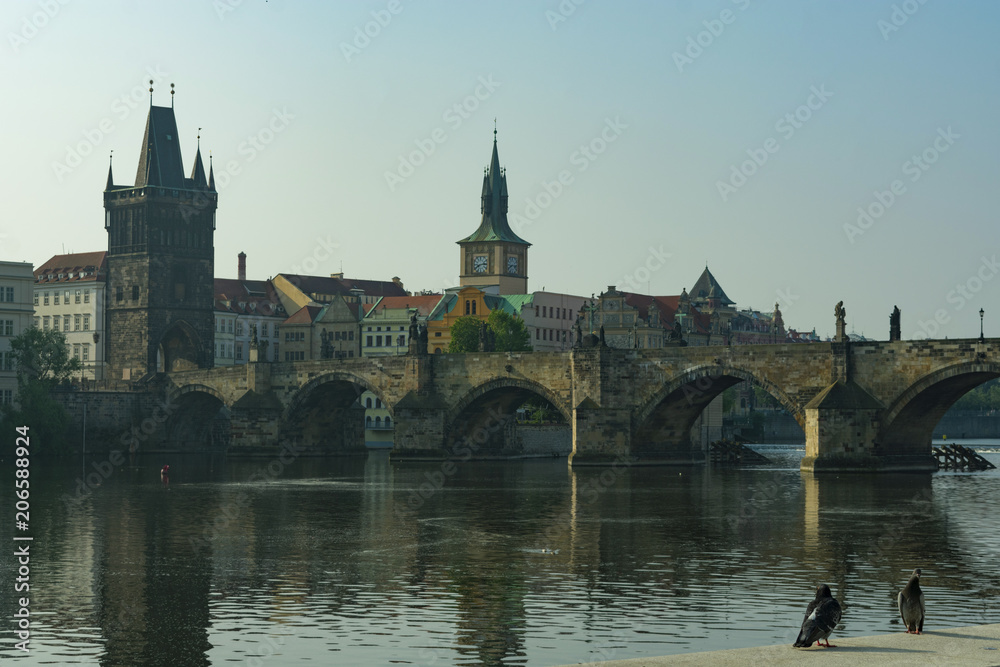 Prague, view of the Charles Bridge and the old tower by the river in the evening