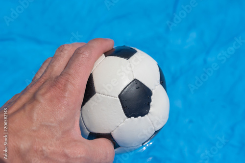 Ball in der Hand - Fußball auf blauem Hintergrund © Tobias