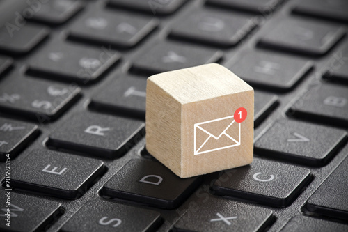 New email graphic on wooden block over laptop keyboard