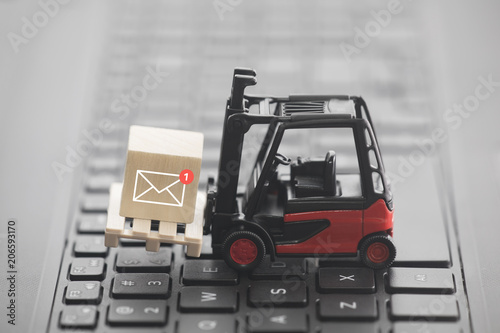 Forklift with new email graphic on wooden block over laptop keyboard 
