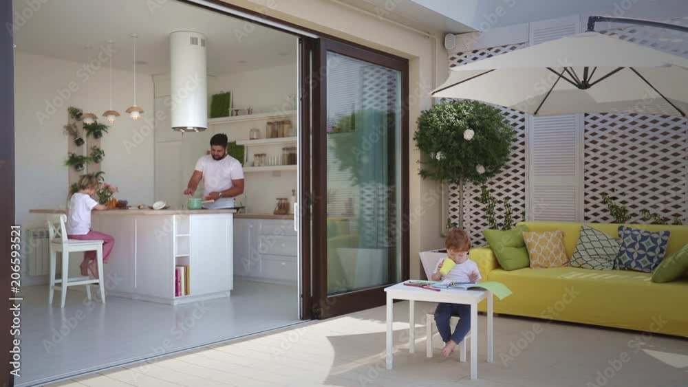 casual domestic lifestyle of family in modern home with sliding door and patio area
