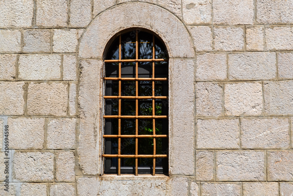 Window with a lattice in the stone wall of the old fortress