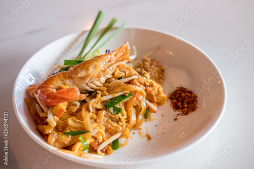 Pad Thai with shrimp serve on plate. It is a stir-fried rice noodle thai dish
