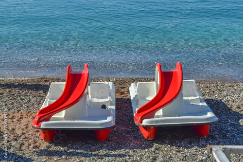 Catamaran boats with slide on a sea coast on a sunny day photo