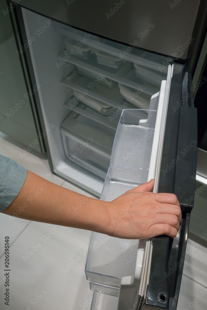 Closed up hand opening the silver color handle of refrigerator door. Closed up hand opening the silver color handle of refrigerator door.