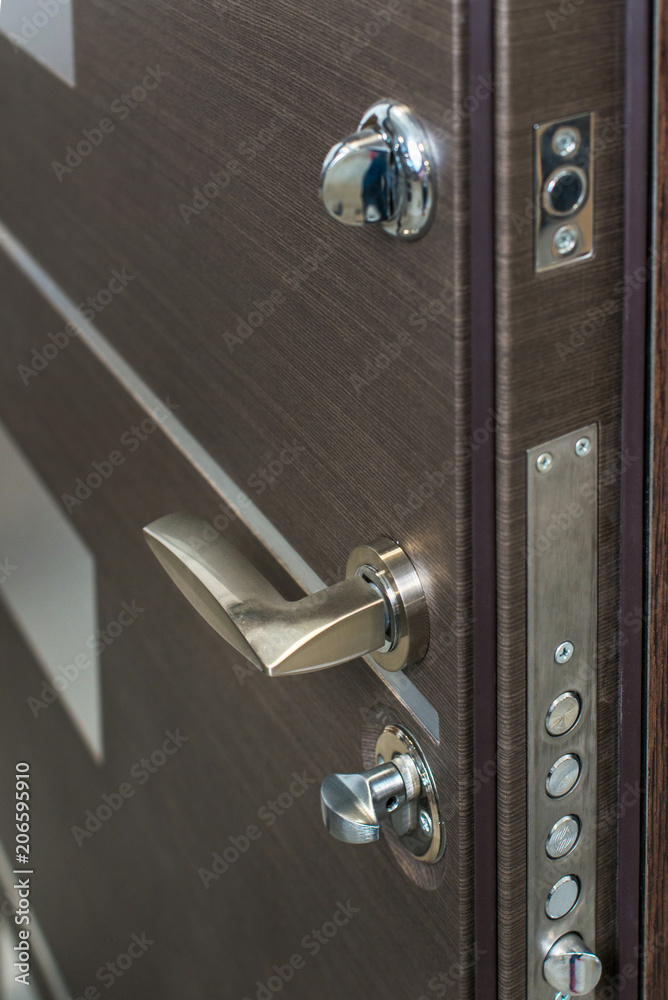 Open armored door. Door lock, Dark brown door closeup. Modern interior design, door handle. New house concept. Real estate. Open armored door. Door lock, Dark brown door closeup. Modern interior design, door handle. New house concept. Real estate.