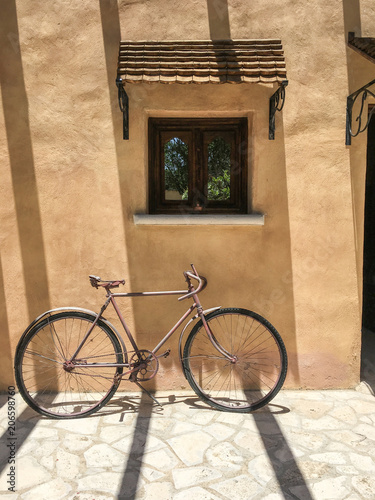 Vintage bike against brown wall. Classic retro bike against brown wall with little window.