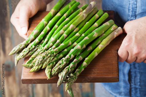 Farmer holding the harvest of young sprouts of asparagus. Organic vegetables.