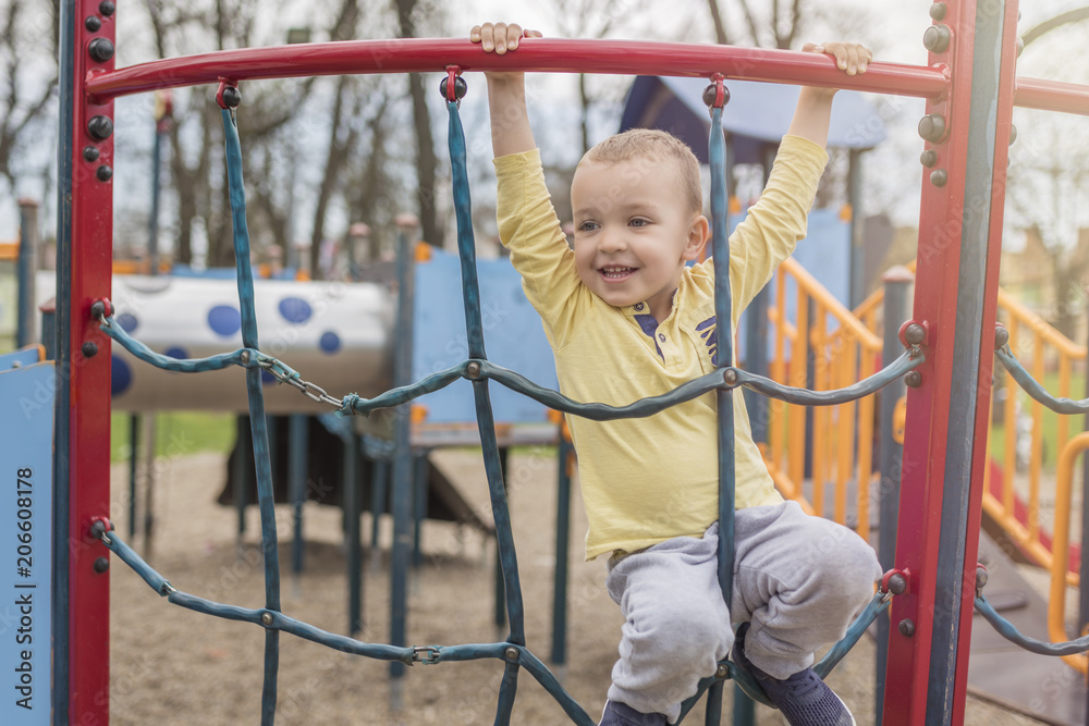 Obraz premium Adorable little boy with blue eyes having fun outdoor