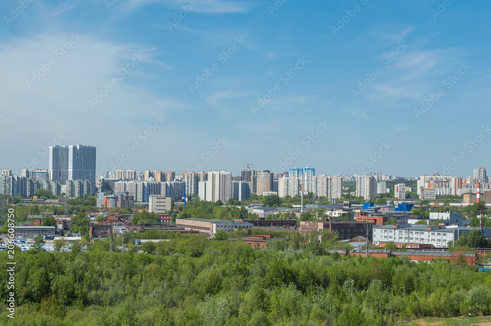 Urban landscape in summer, industrial chimneys and high blocks of flats in big city