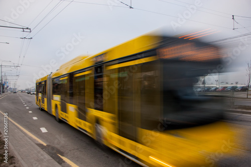 The motion of a blurred bus on the avenue during the day.