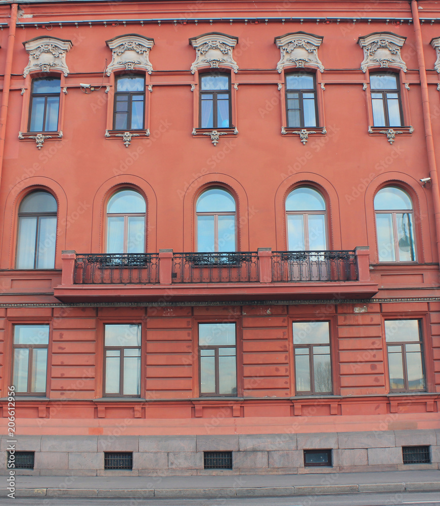 Architecture Building Classic Decor Facade of Old Historic House with Light Red Color Walls. European Architecture Exterior Design of Apartment Building with Balcony Front View Facing City Street.