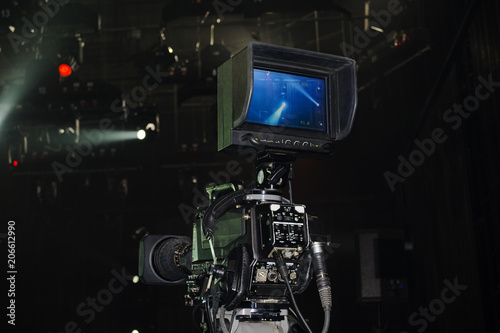 Professional video camera film concert on stage.Big pro 4k video cam shoots live broadcast footage for television.TV camera operator shooting videos on concert stage