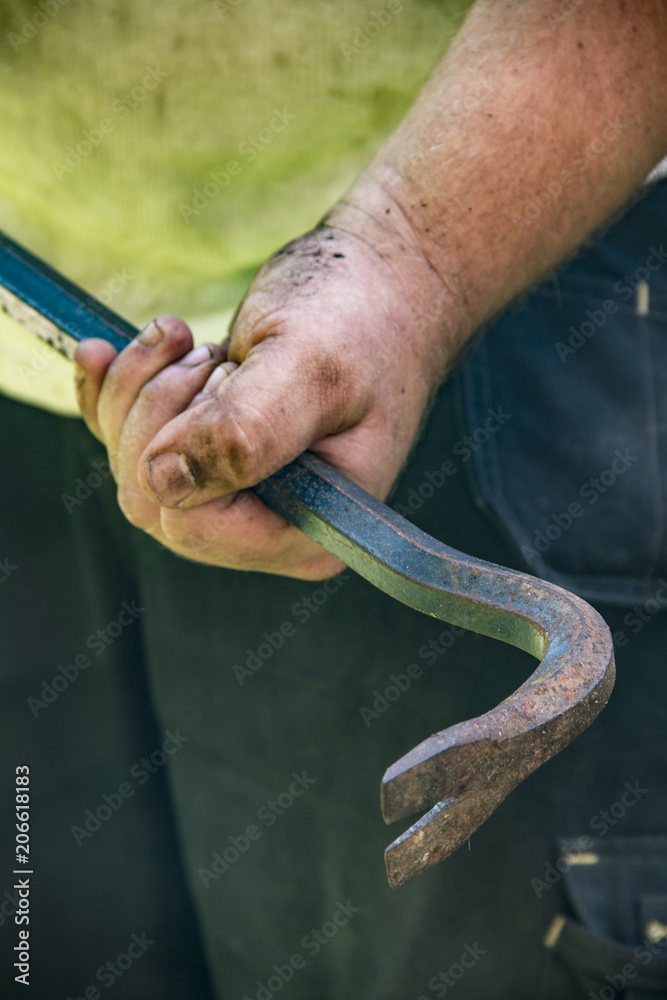 Fototapeta premium Mann hält Brechstange in Hand