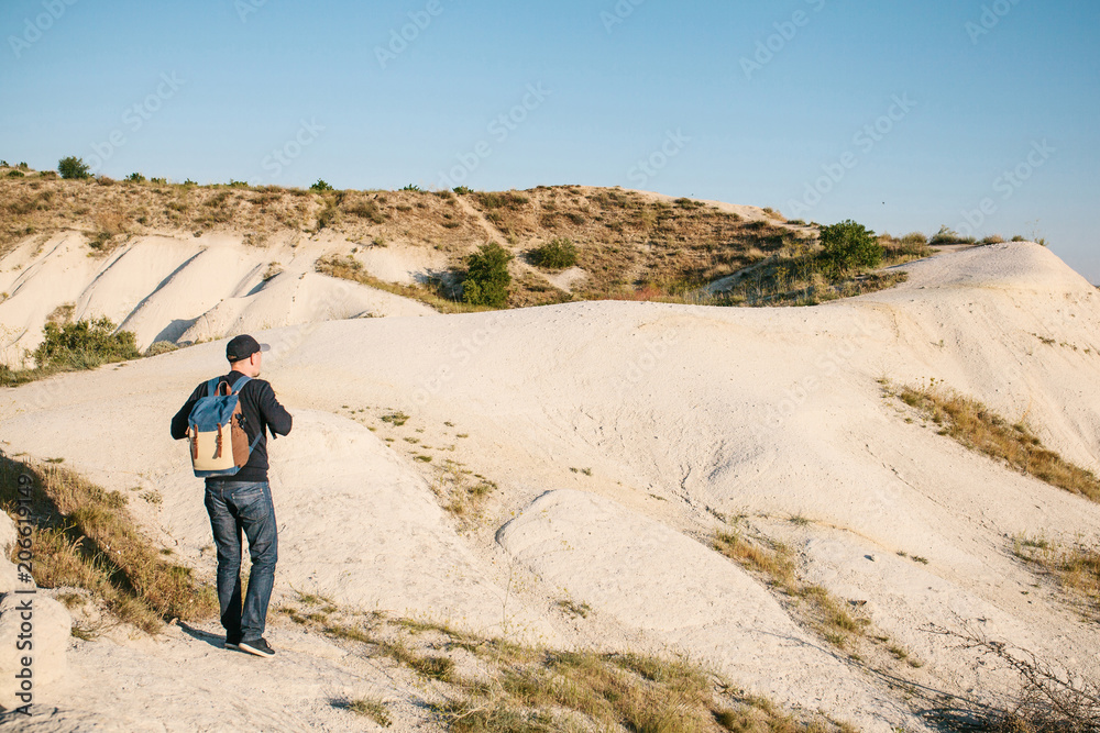 A tourist with a backpack travels to the beautiful places of Cappadocia in Turkey. A solitary walking tour in the mountains A tourist with a backpack travels to the beautiful places of Cappadocia in Turkey. A solitary walking tour in the mountains
