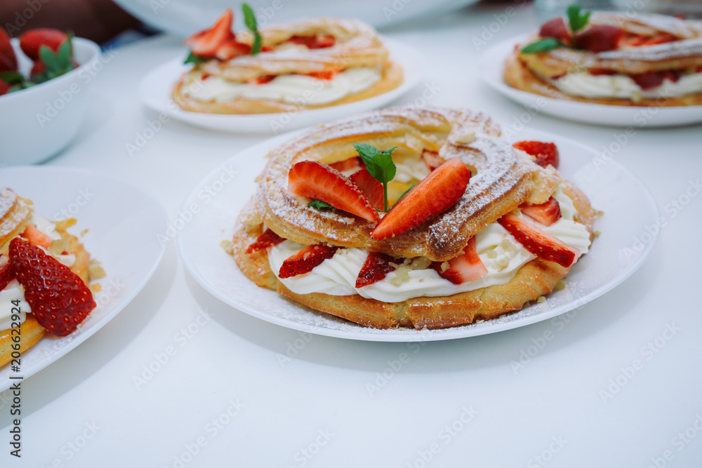 Cakes Paris Brest with strawberries, mint on white table Cakes Paris Brest with strawberries, mint on white table