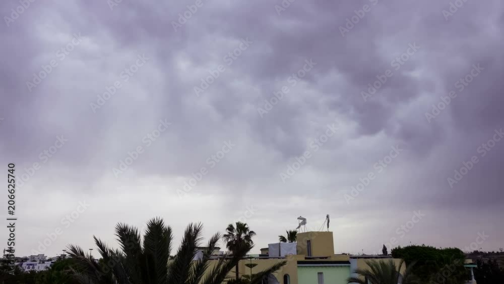 Dark clouds before a thunderstorm over the roofs of houses. Background of storm clouds before a thunder-storm. Time Lapse. Timelapse. Dark clouds before a thunderstorm over the roofs of houses. Background of storm clouds before a thunder-storm. Time Lapse. Timelapse.