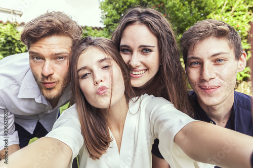 group of young people take a selfie hugged together