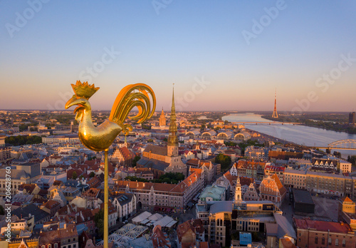 Amazing aerial view of the sunset over Old town of Riga, Vecriga in Latvia. River Daugava, with Domes cathedral and golden cock in the foreground. 