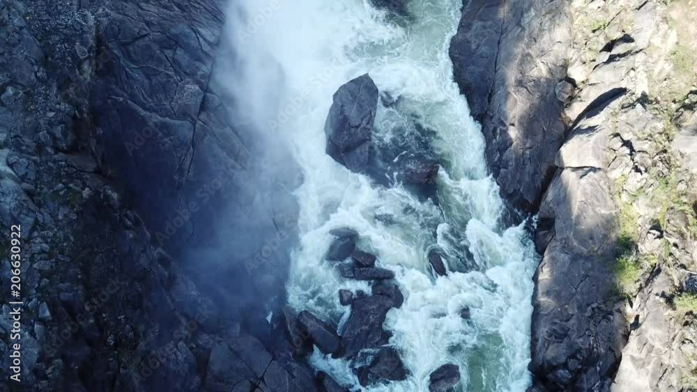 River flows fastly through stones. Buttom of the dam.