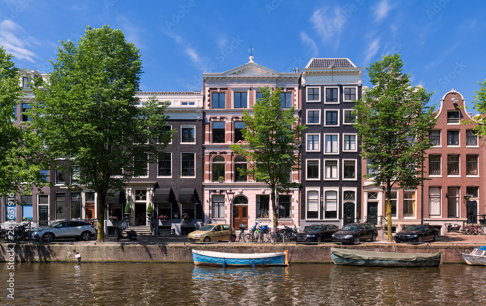 Typical old houses of Amsterdam under blue sky.