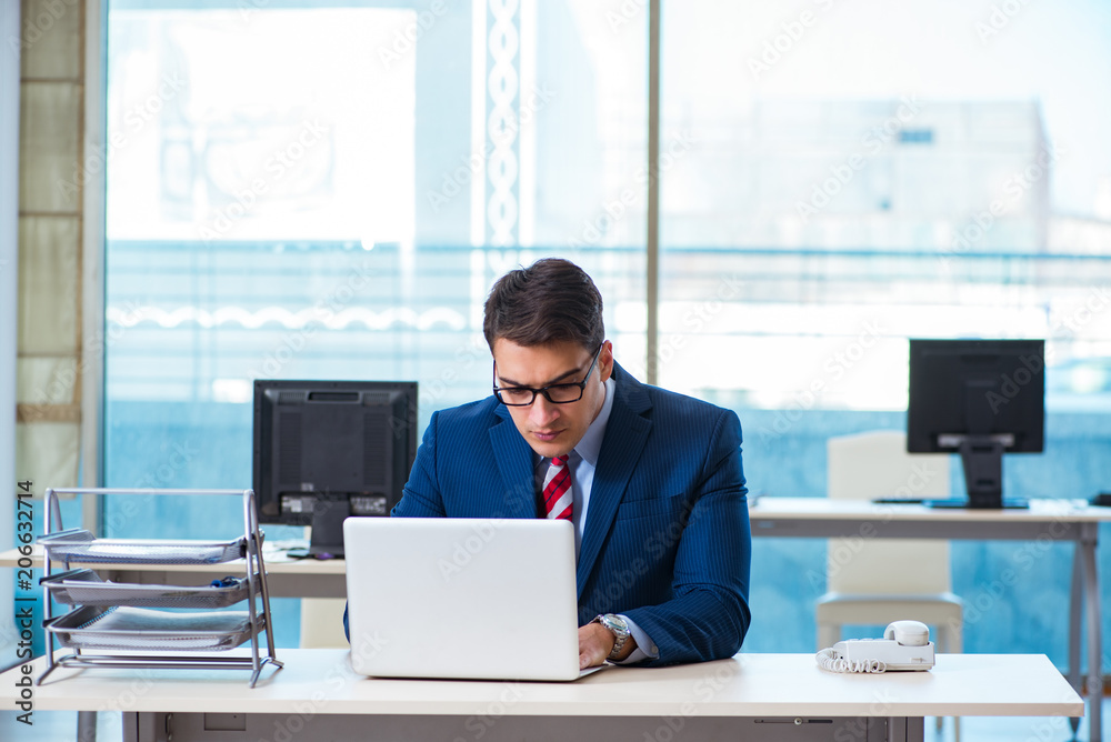 Young handsome businessman employee working in office at desk Young handsome businessman employee working in office at desk