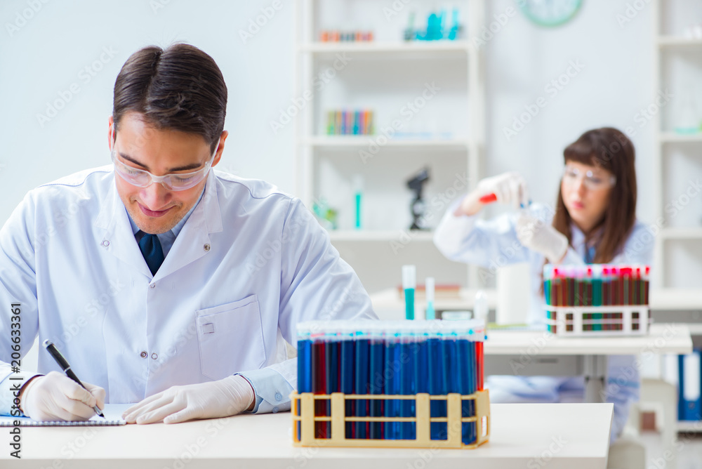 Two chemists working in lab experimenting Two chemists working in lab experimenting