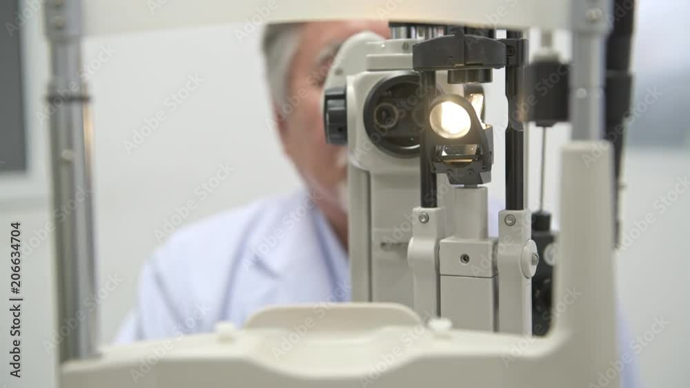 Optician at work in hospital. Senior chinese optician using eye scanner, POV style. Eye care concept. Optician at work in hospital. Senior chinese optician using eye scanner, POV style. Eye care concept.