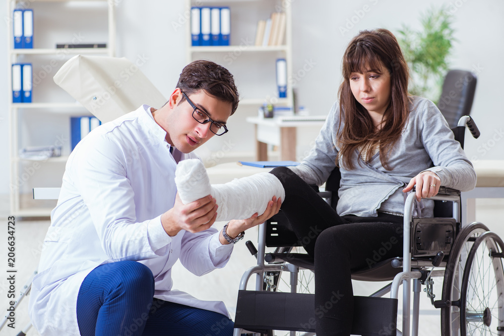 Male doctor examining female patient on wheelchair Male doctor examining female patient on wheelchair