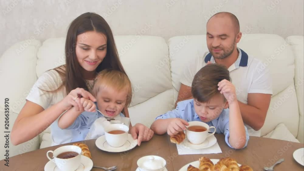 Little boy spilling the tea over the table making his dad embarrassed Little boy spilling the tea over the table making his dad embarrassed