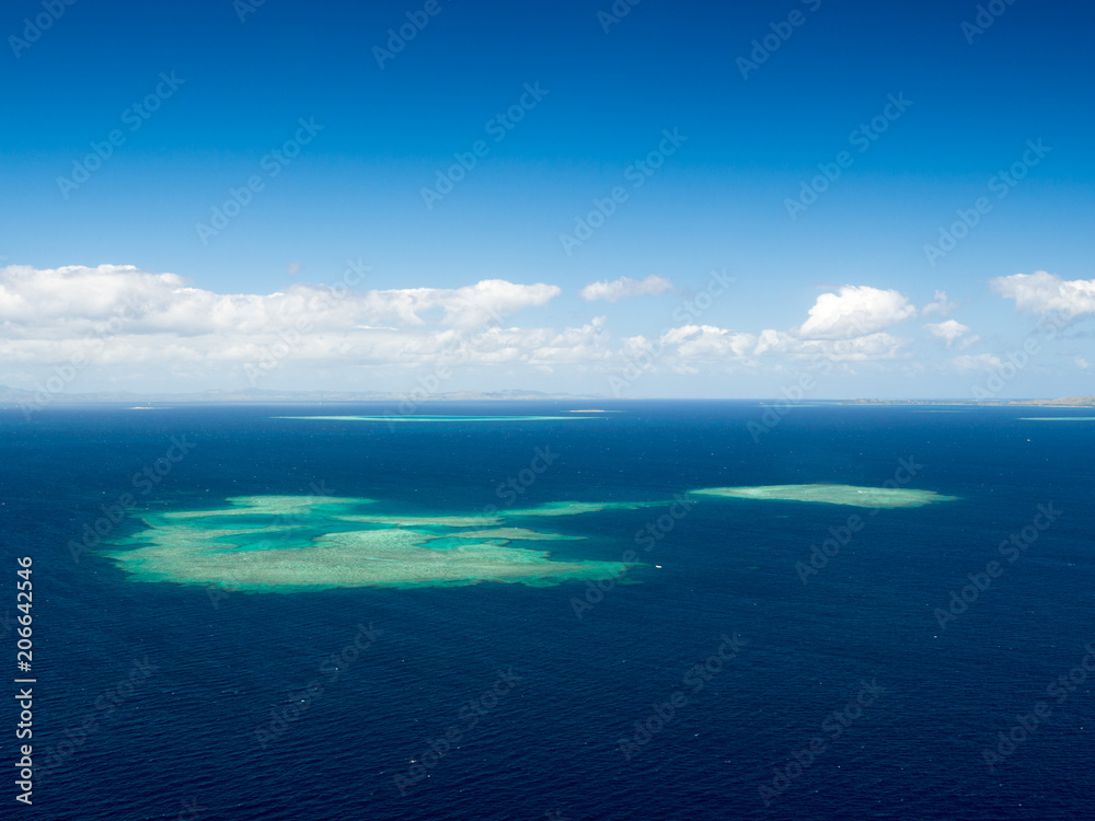 Aerial Landscape View of South Pacific Reef Island Surrounded by Deep Blue Ocean in Summer Weather