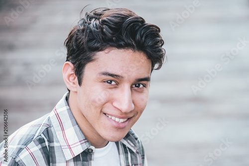 Closeup of handsome young male smiling into the camera outdoors  © mdurson