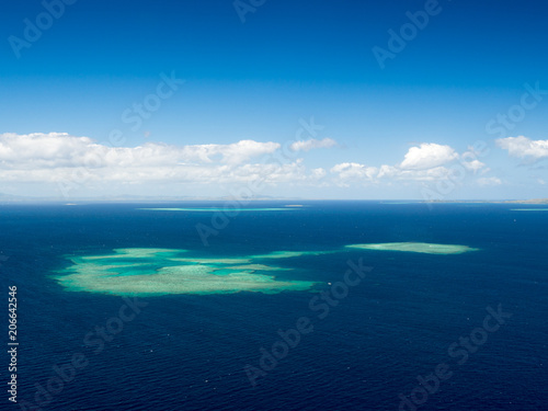 Aerial Landscape View of South Pacific Reef Island Surrounded by Deep Blue Ocean in Summer Weather