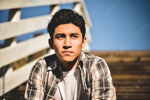 Young hispanic latino male looking off into the distance, serious facial expression  photo