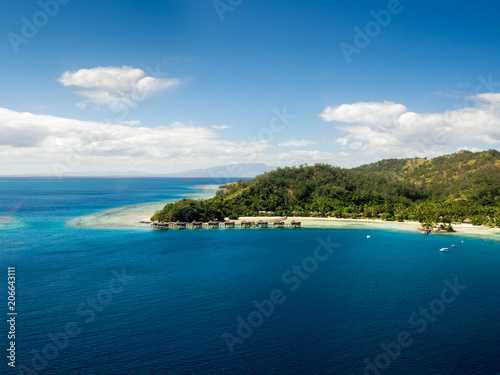 Aerial Landscape View of Tropical South Pacific Island Over Water Bure Resort Surrounded by White Sand Beach, Ocean and Reef in Fiji