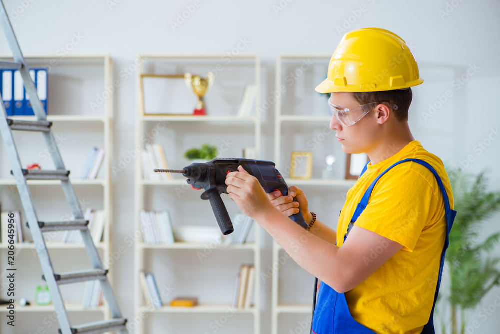 Young repairman with power drill Young repairman with power drill