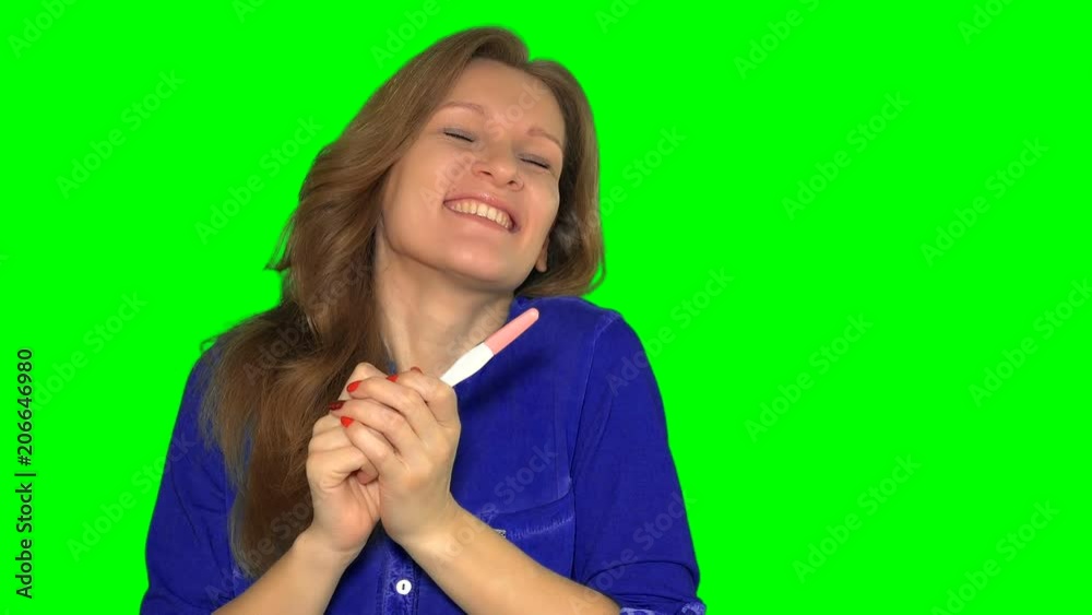 happy smiling woman looking at pregnancy test happy smiling woman looking at pregnancy test