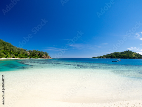 Fototapeta Naklejka Na Ścianę i Meble -  Beautiful Landscape of Reef and Turquoise Aqua Blue Clear Ocean Water with White Sand Beach and Palm Trees on Tropical Pacific Island of Fiji