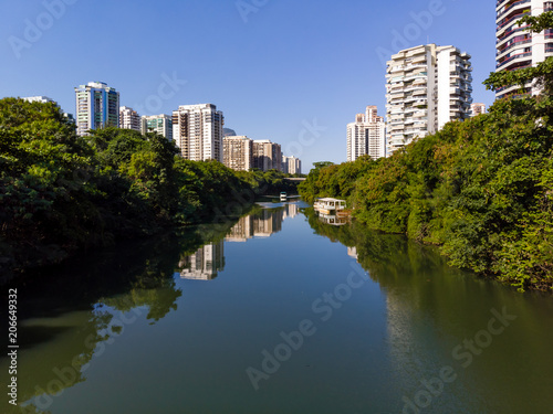 Aerial view of Marapendi canal in Barra da Tijuca on a summer day. Tall residential skyscrapers on both sides, with green vegetation